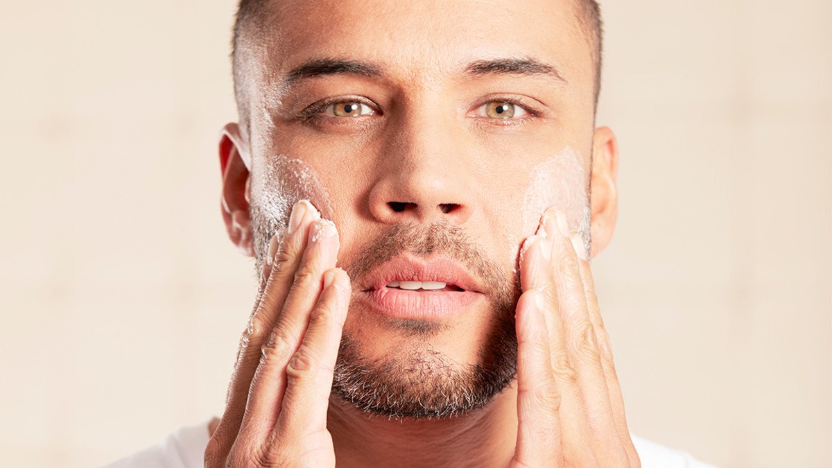 portrait-of-mid-adult-man-using-skin-care-product